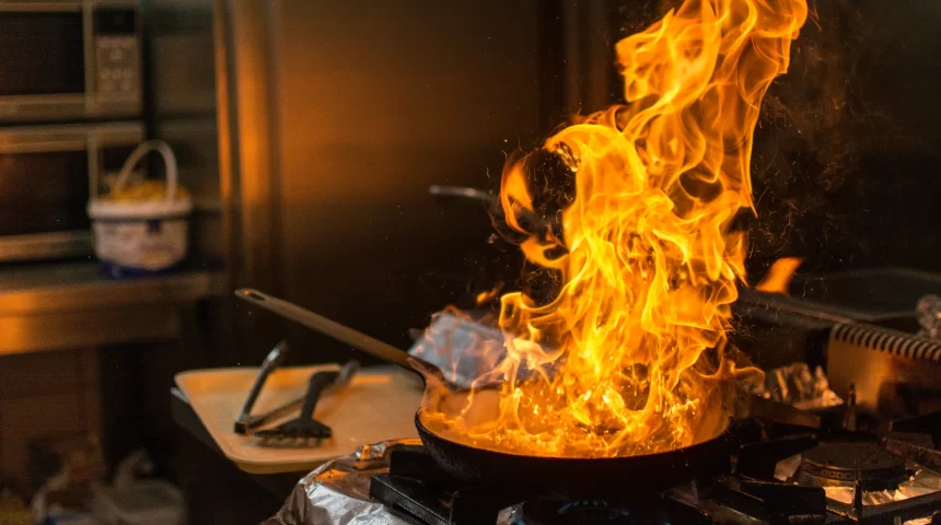 frying pan on fire inside of a kitchen